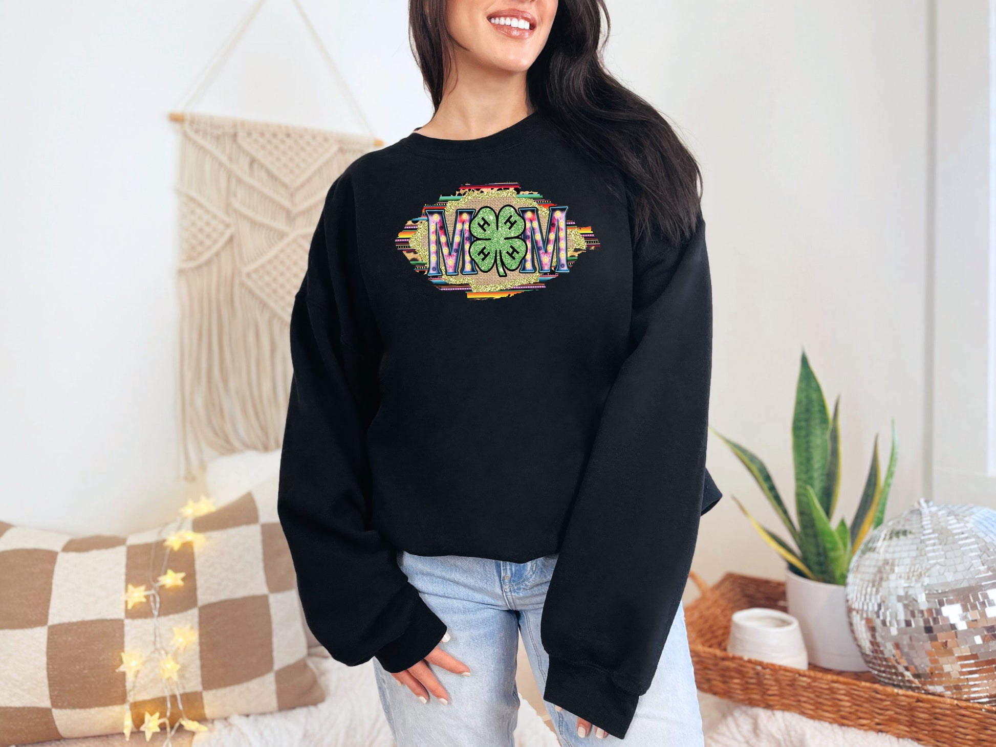 a woman wearing a black sweatshirt with the word mom on it